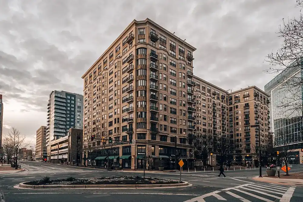 Brick apartment tower at a downtown street corner in Bethesda, Maryland, under a cloudy sky