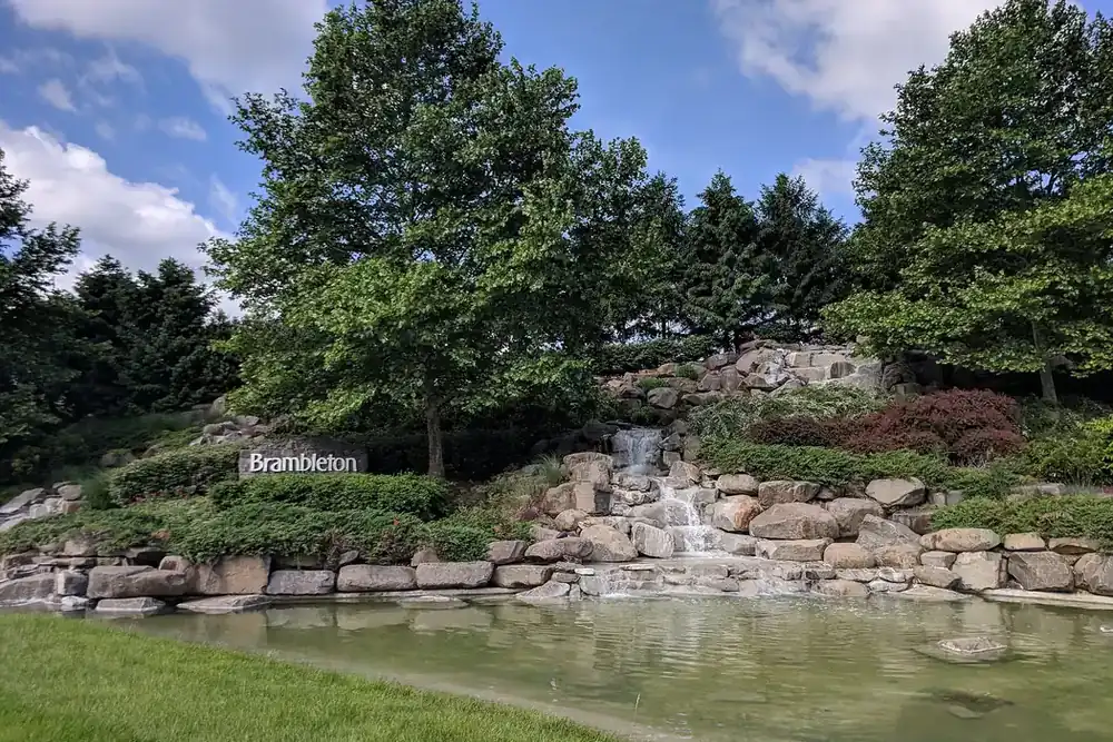 Rock waterfall and pond at a landscaped community entrance in Brambleton, Virginia