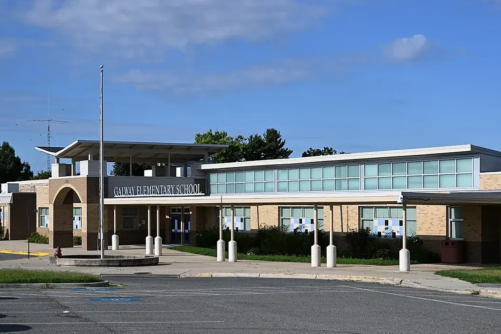 Tan brick Galway Elementary School with a covered walkway under a blue sky in Calverton, Maryland