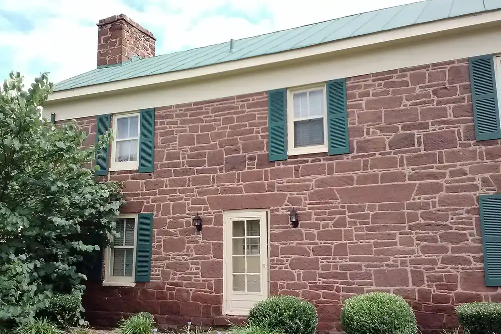 Historic stone building with green shutters and a metal roof in Chantilly, Virginia