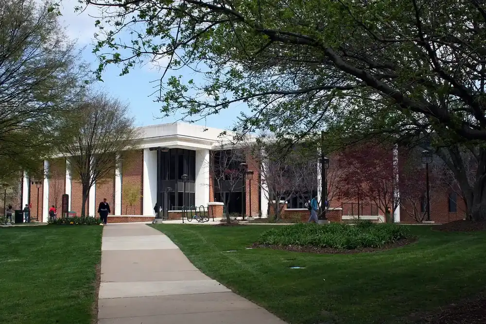 Library building with white columns across a tree-shaded lawn at the George Mason University campus, Virginia