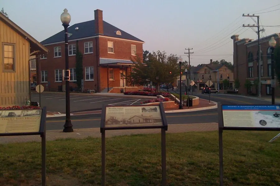 Historic depot area with a brick building and interpretive markers in Herndon, Virginia