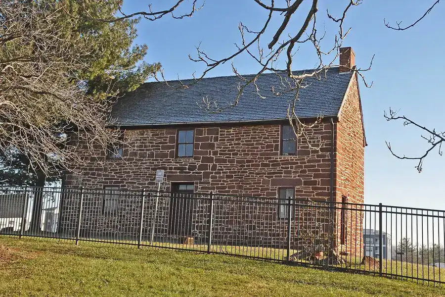Historic stone Conner House behind an iron fence in Manassas Park, Virginia